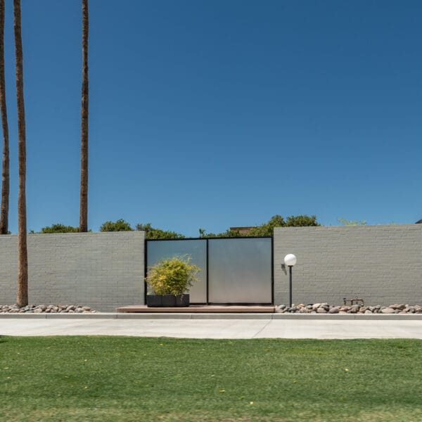 Al Beadle mid-century modern home in Phoenix with walled entry, flat roofline, palms, desert landscape, and restrained modernist design.