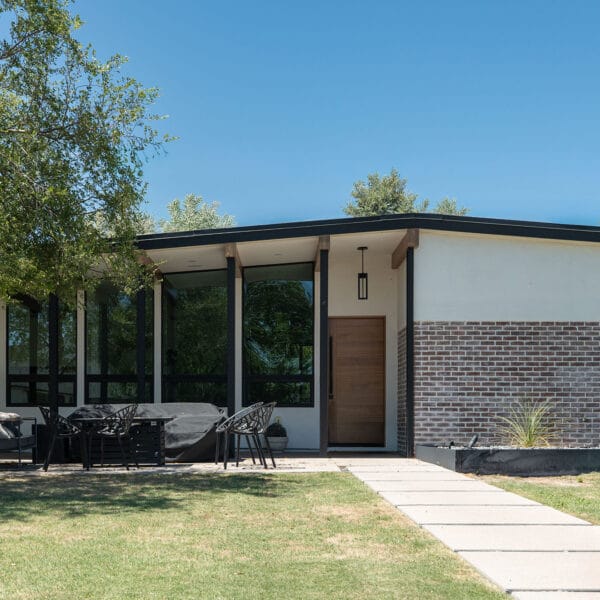 Schreiber mid-century modern home in Arcadia Phoenix with low roofline, brick detail, shaded glass entry, and mature landscaping.