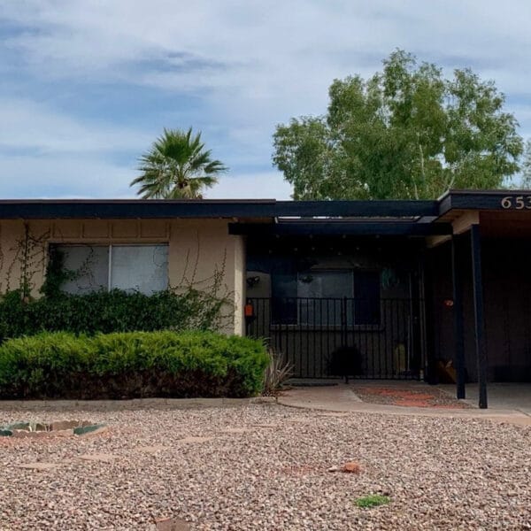 Mid-century modern home in Hy-View Scottsdale with carport, low roofline, gravel landscape, covered entry, and mature landscaping.