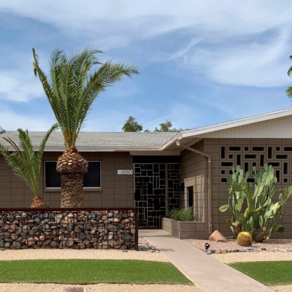 Mid-century modern home in Hy-View Scottsdale with geometric breeze block, low roofline, cactus landscaping, palm trees, and desert modern design.