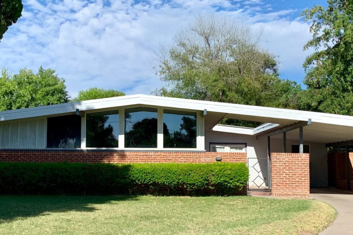 Ralph Haver mid-century modern home in Janet Manor Phoenix with brick facade, low roofline, clerestory windows, carport, and front lawn.