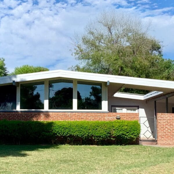 Ralph Haver mid-century modern home in Janet Manor Phoenix with brick facade, low roofline, clerestory windows, carport, and front lawn.