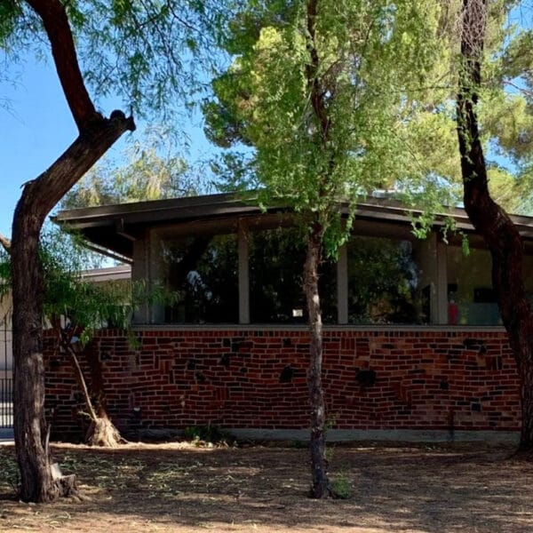 Ralph Haver mid-century modern home in Janet Manor Phoenix with clinker brick wall, low roofline, clerestory windows, shaded entry, and mature trees.