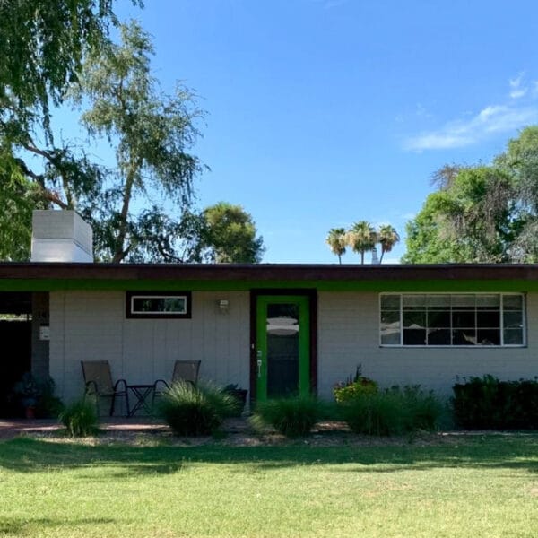 Ralph Haver mid-century modern home in Mayfair Manor Phoenix with green front door, low roofline, carport, horizontal windows, and front lawn.
