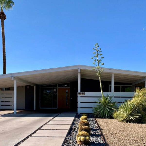 Ralph Haver mid-century modern home in Northwood Phoenix with carport, low roofline, orange front door, desert landscaping, and palm tree.
