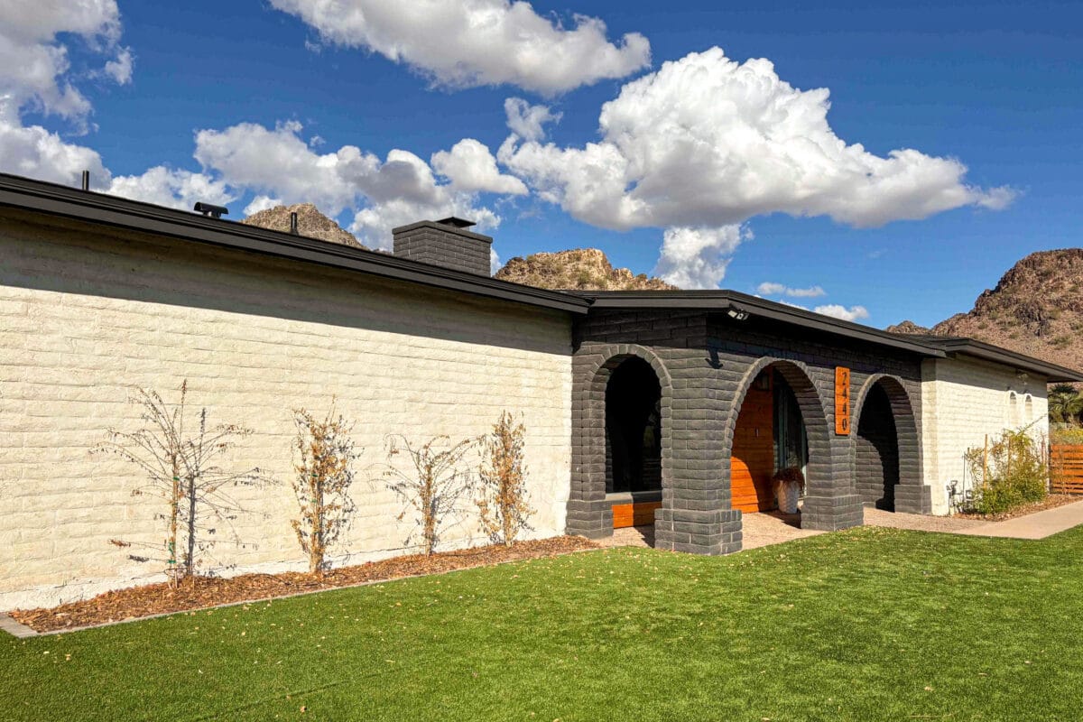 Front elevation of the Piestewa Peak Renovation & Addition in Phoenix featuring painted brick arches, a cedar entry, and mountain views.
