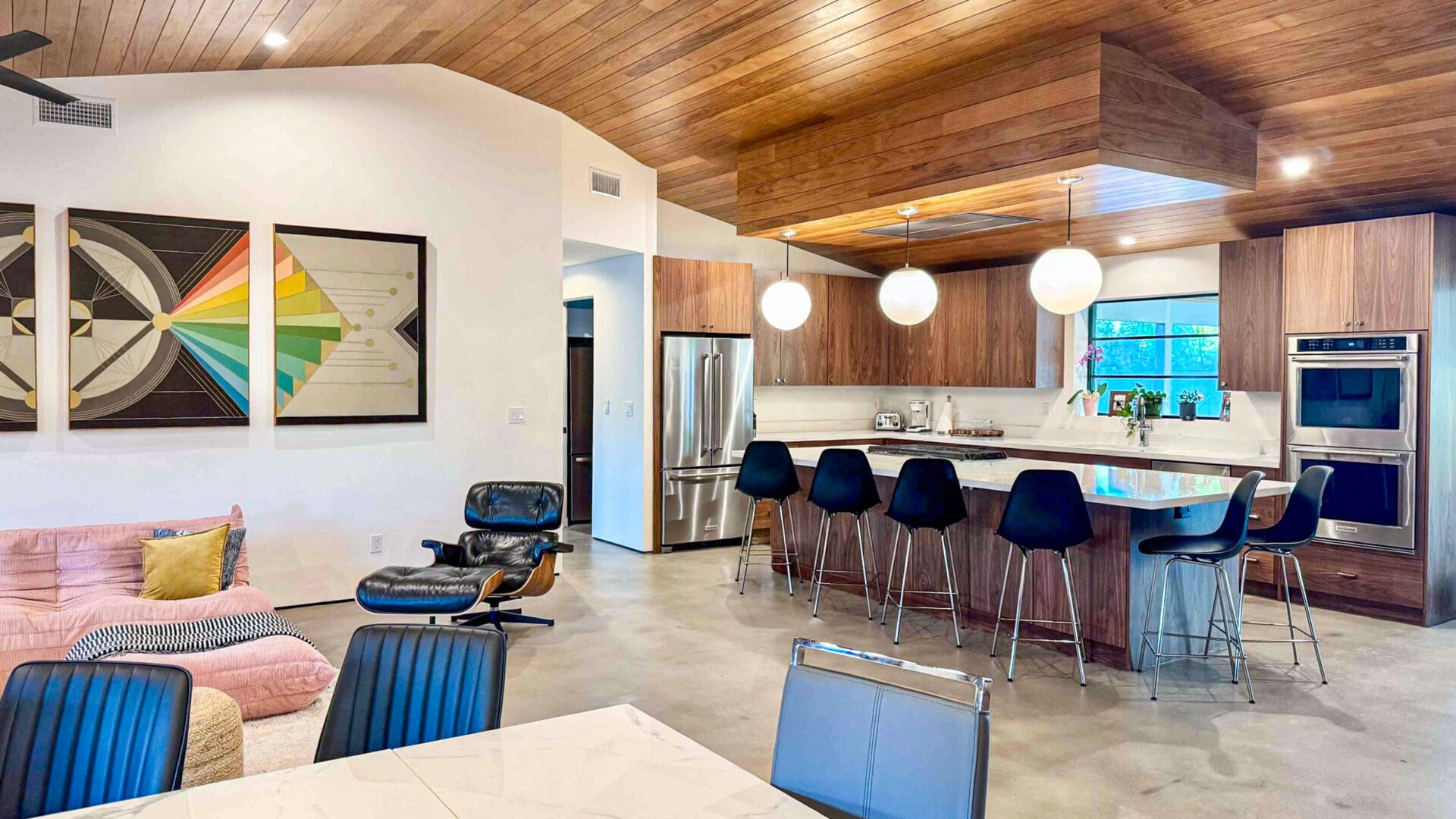 Rose Lane renovation great room in Phoenix with open-concept living, wood ceiling, modern kitchen, globe lighting, and mid-century modern design.