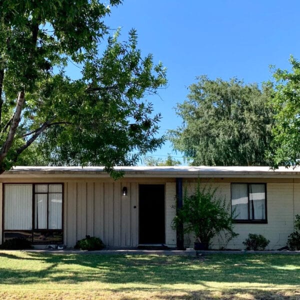 Ralph Haver mid-century modern home in Starlite Vista Phoenix with low roofline, mature trees, front lawn, integrated garage, and shaded entry.