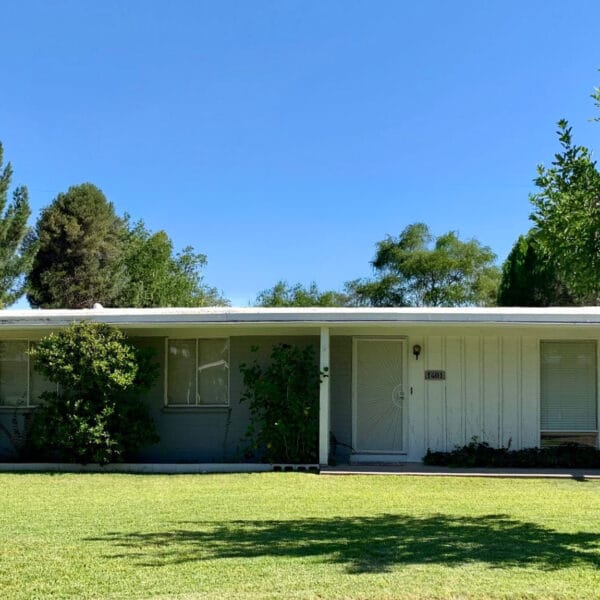Ralph Haver mid-century modern home in Starlite Vista Phoenix with white front door, low roofline, front lawn, carport, and mature landscaping.