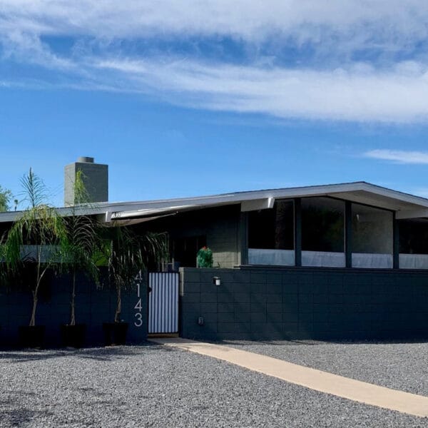 Ralph Haver mid-century modern home in Town and Country Manor Phoenix with gray block exterior, low roofline, clerestory windows, palm tree, and desert landscaping.