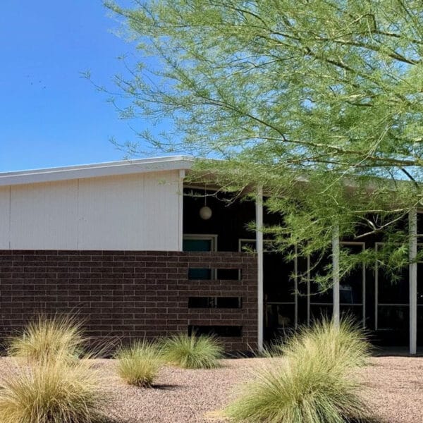 Charles and Arthur Schreiber mid-century modern home in Village Grove South Scottsdale with brick facade, low roofline, shaded entry, and desert landscaping.